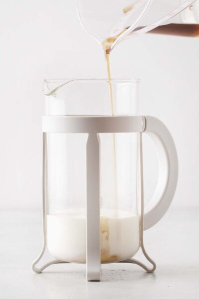 Brown sugar syrup poured into a French press with milk. 