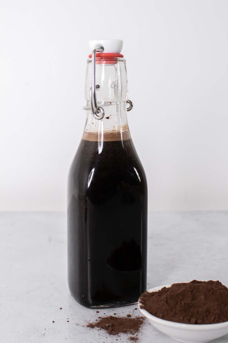 Chocolate syrup in a glass bottle.