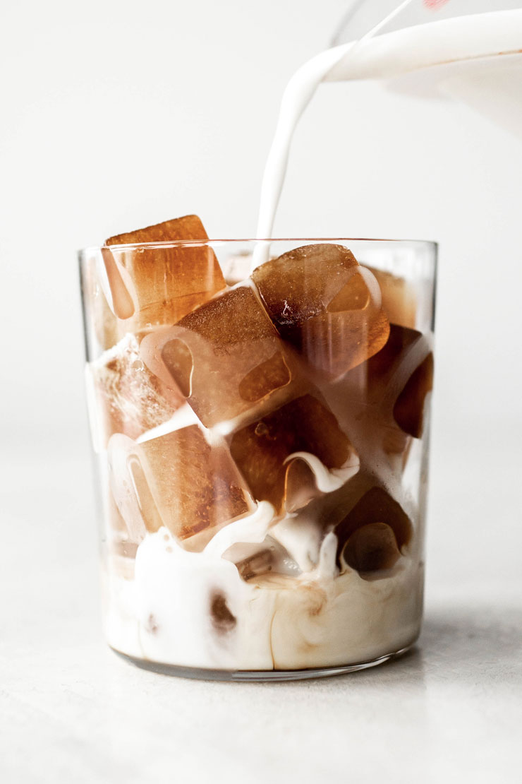 Coffee ice cubes and milk in a cup