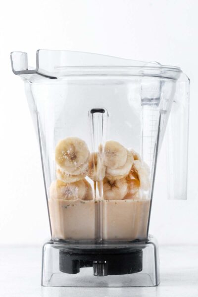 Bananas, hemp seeds, coffee, and oat milk in a blender. 