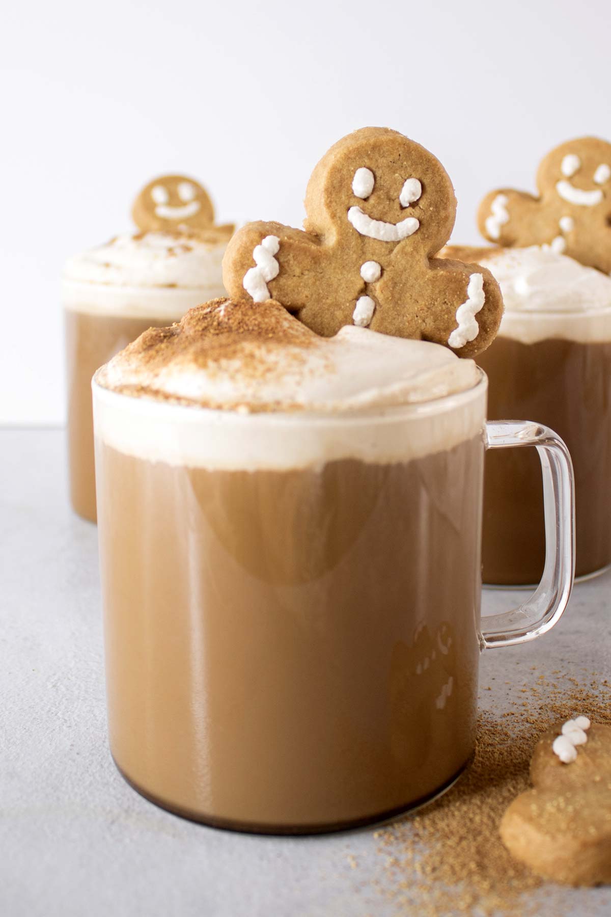 Gingberbread lattes topped with whipped cream and gingerbread man cookie.