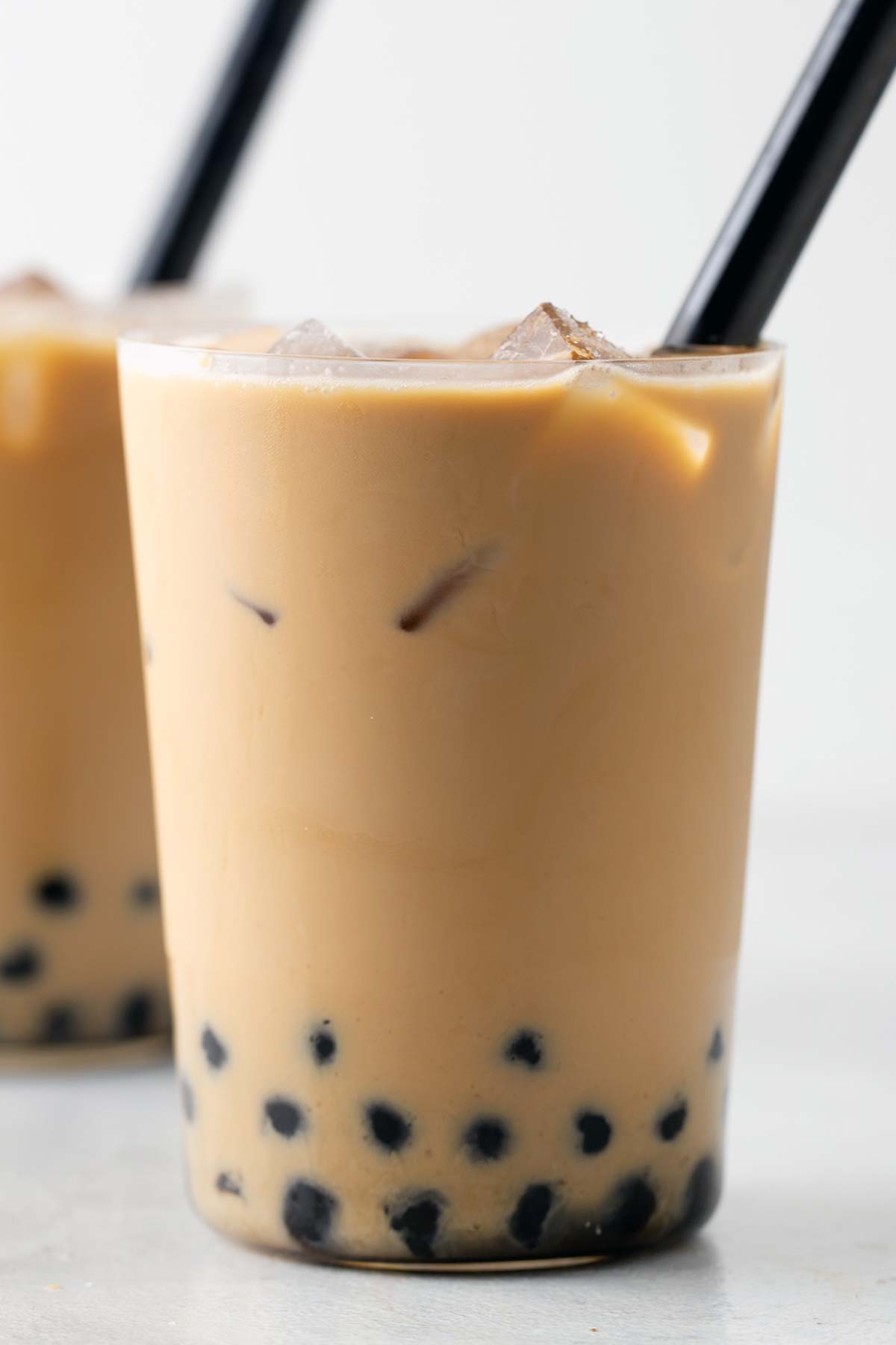 Iced Coffee Boba in a clear class with large black straw.