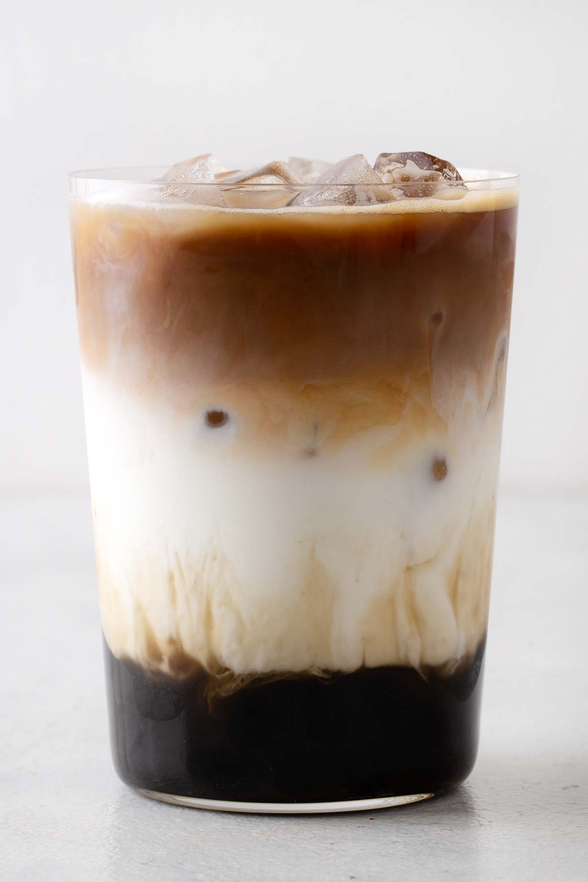 Iced Latte with Boba in a glass to clearly see the drink's layers.