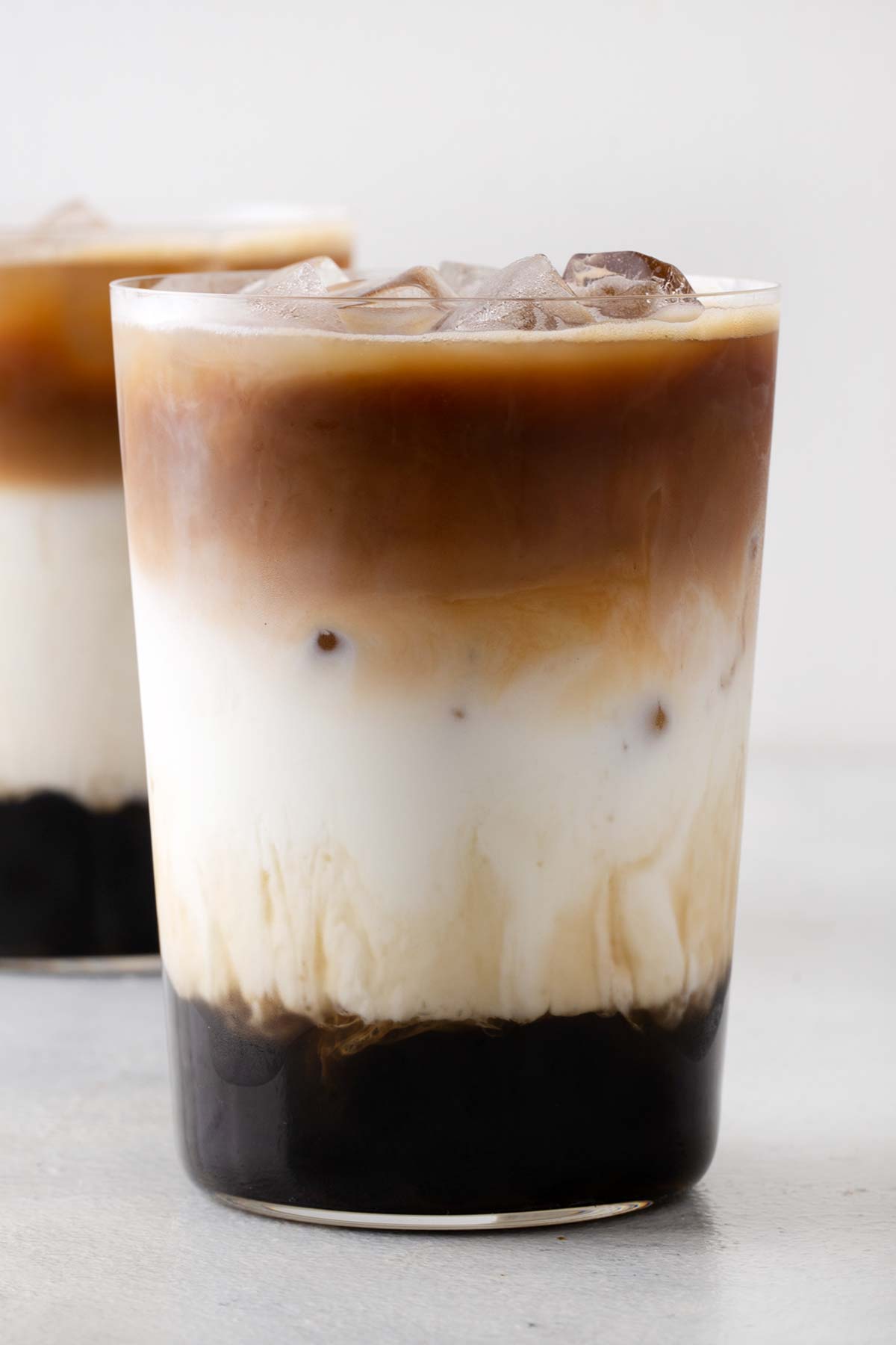 Es kopi latte dengan boba dalam gelas bening dengan es.