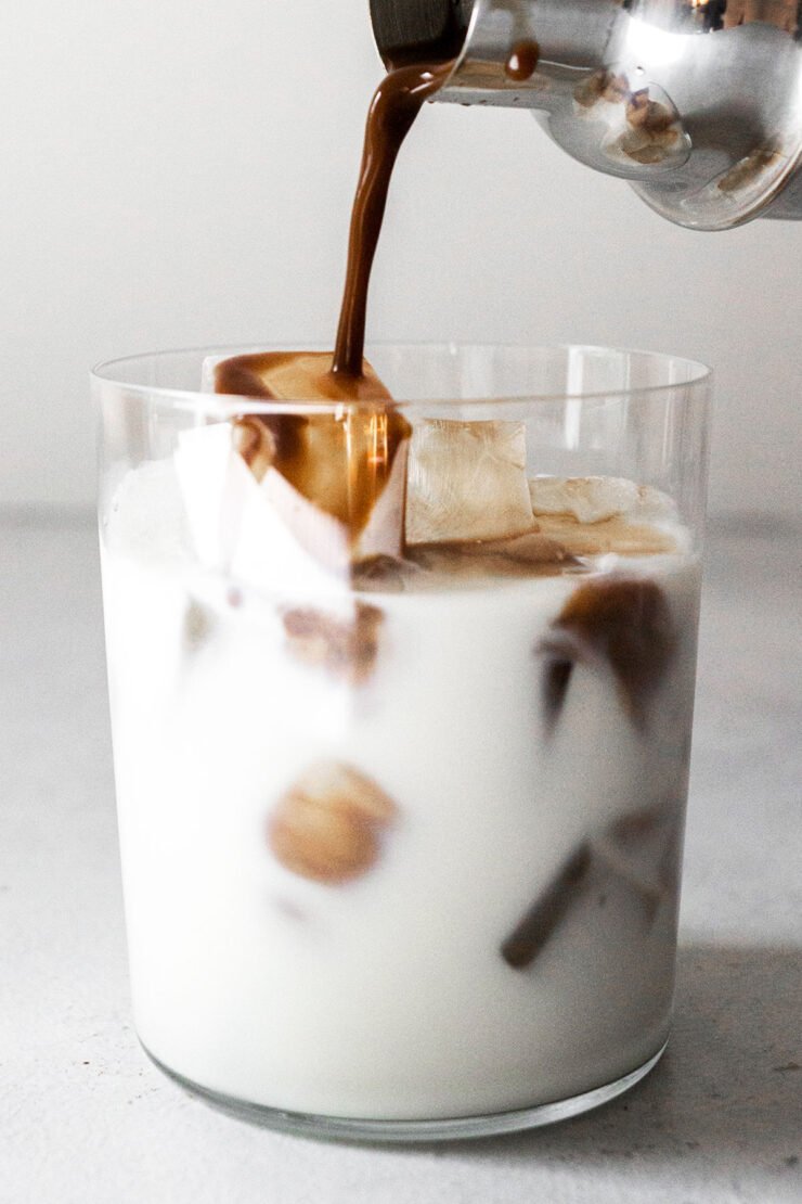 Pouring mocha into a cup of ice and milk.