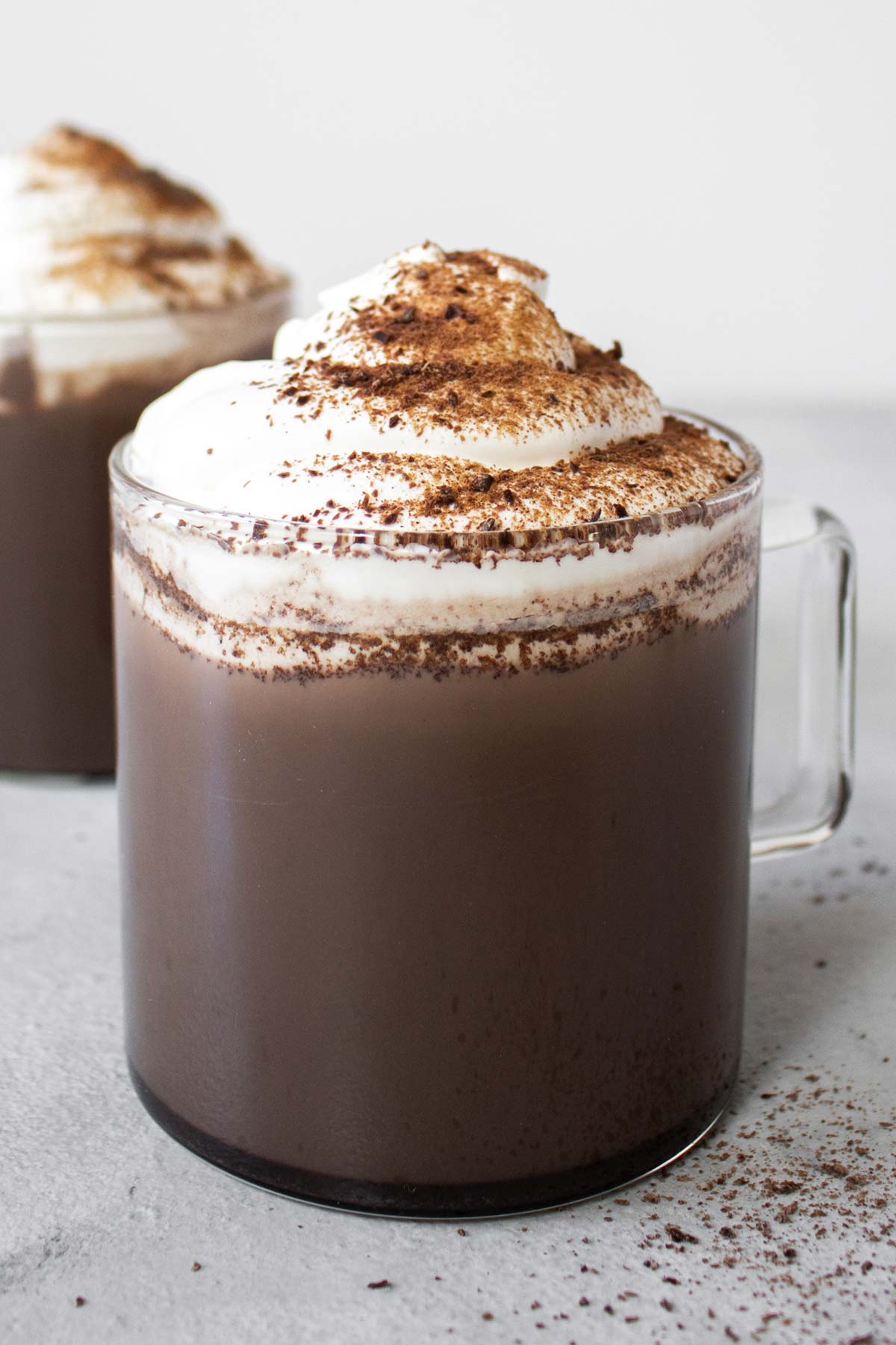 Mexican hot chocolates in glass mugs with whipped cream.
