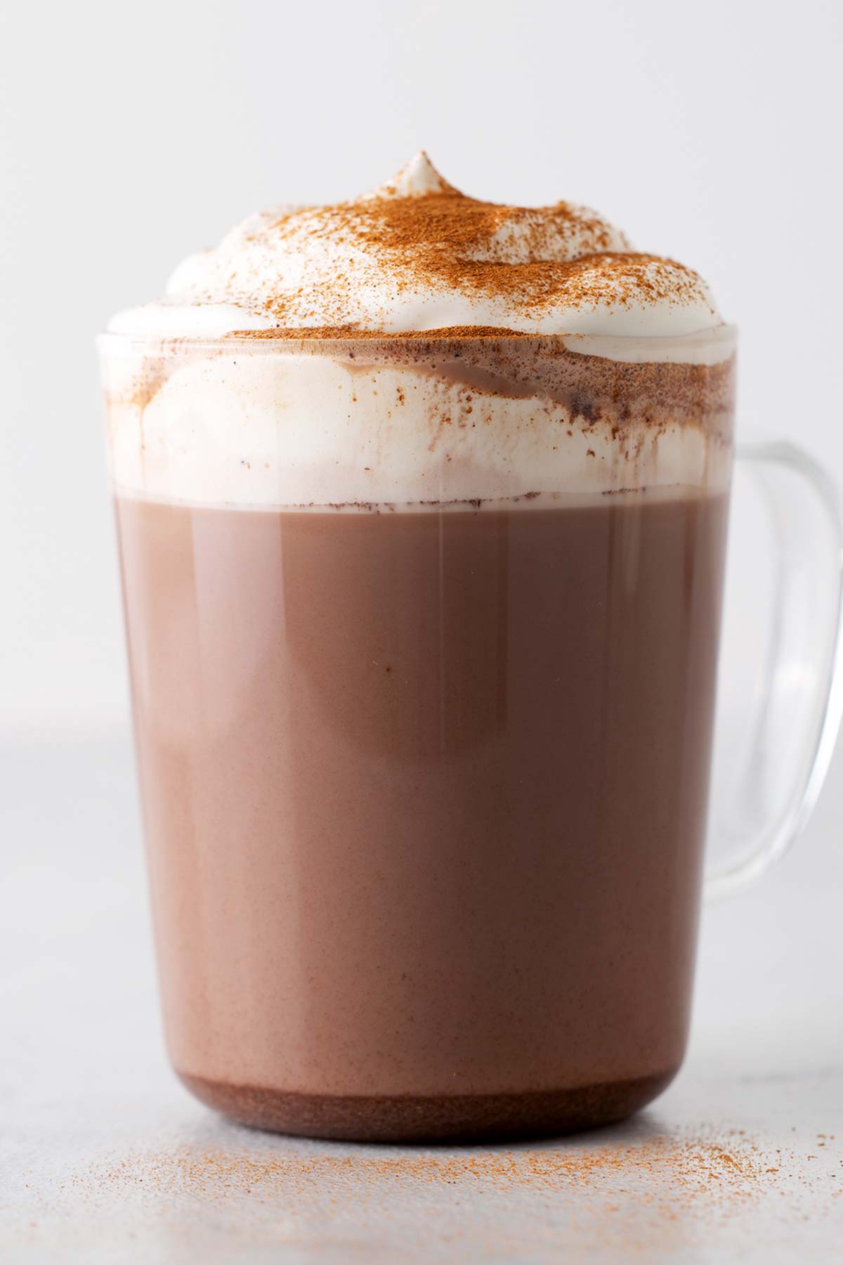 Mexican Hot Chocolate in a glass mug with whipped cream.