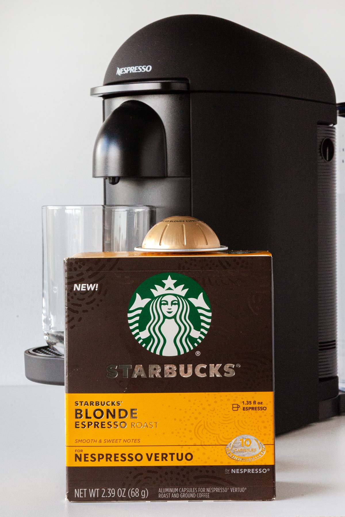Nespresso Starbucks Blonde Espresso capsule box in front of a Nespresso machine.
