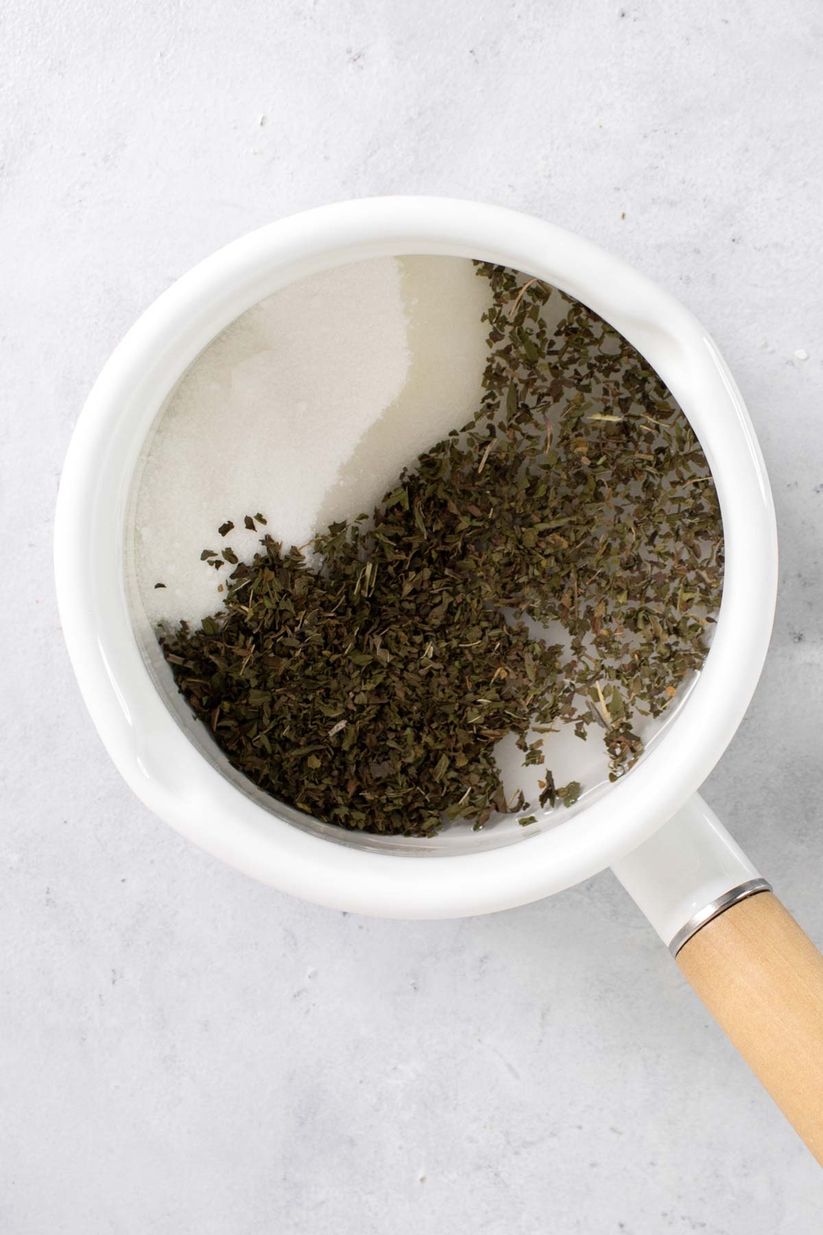 Water, sugar, and peppermint tea in a saucepan.