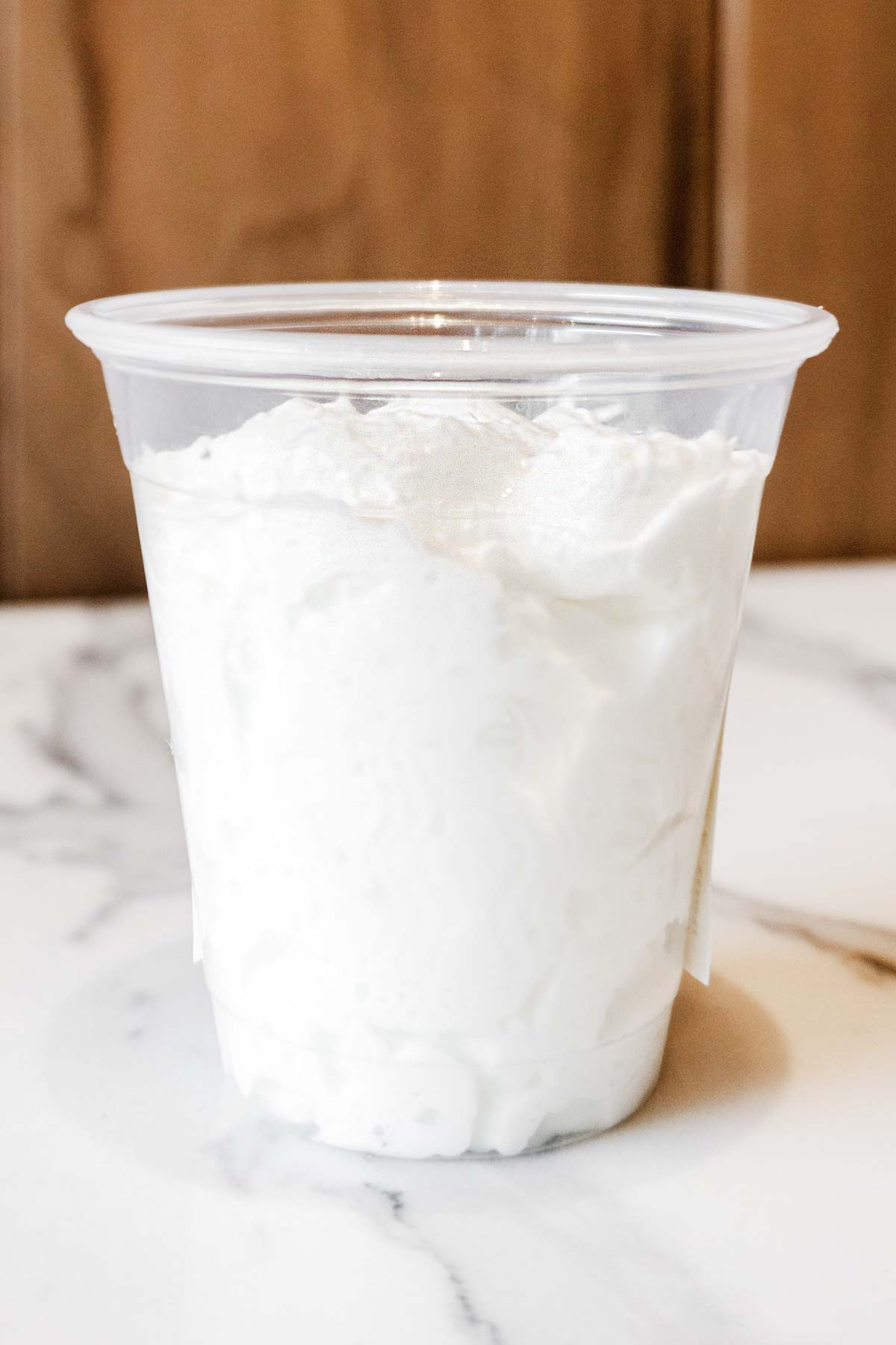 Starbucks Puppuccino (whipped cream) in a small plastic cup.