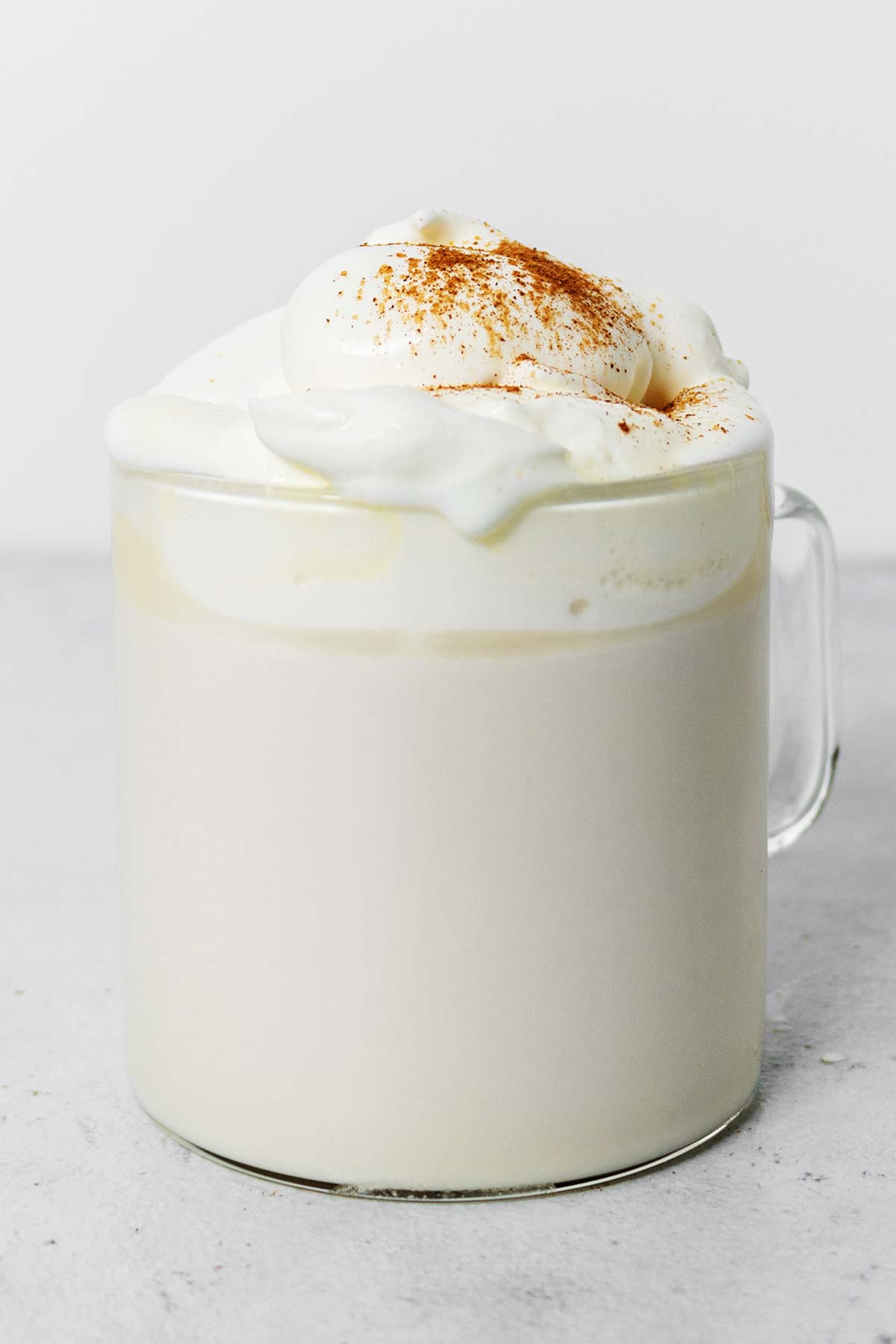 Snickerdoodle white hot chocolate in a glass mug.
