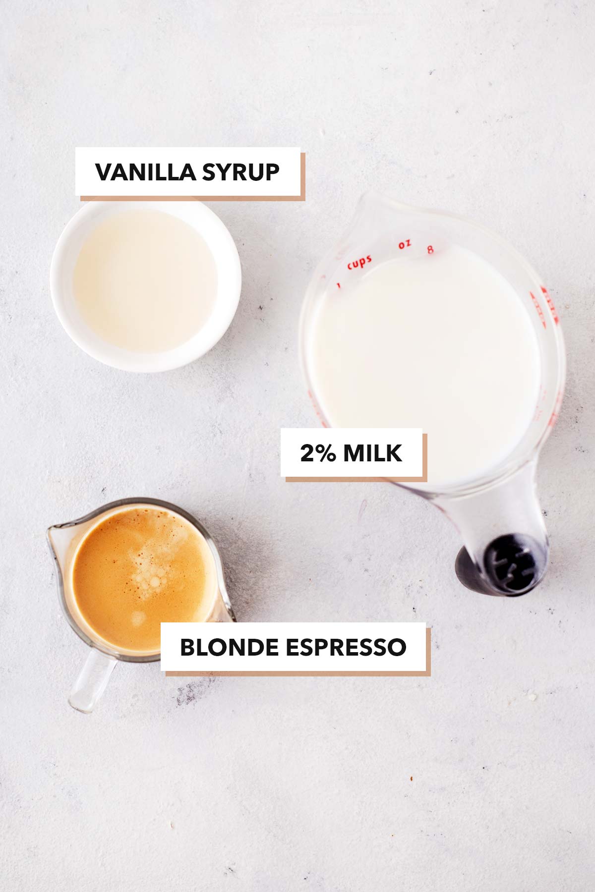 Starbucks Blonde Vanilla Latte copycat drink ingredients in measuring cups on a table.