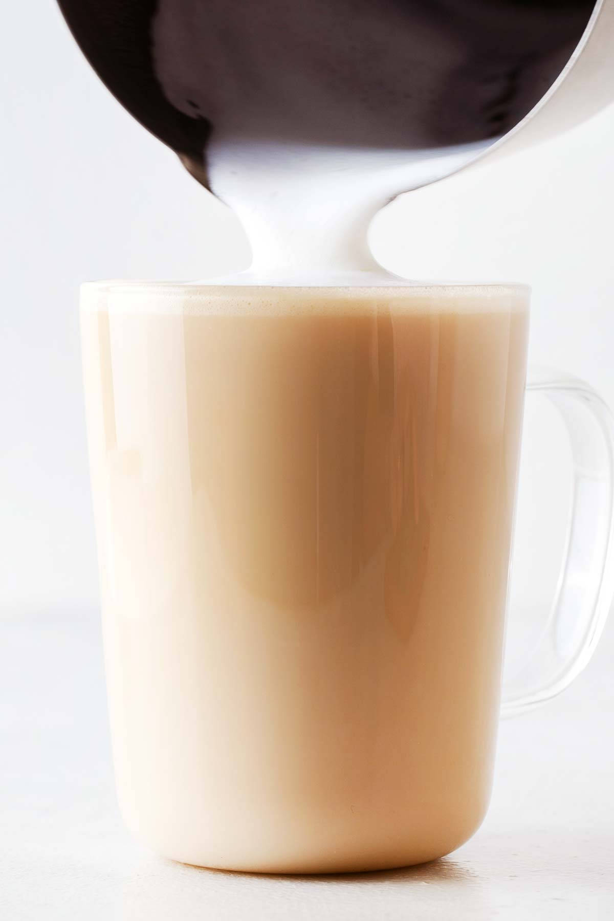 Starbucks Blonde Vanilla Latte minuman tiruan dengan susu kukus terakhir dituangkan ke dalam cangkir.