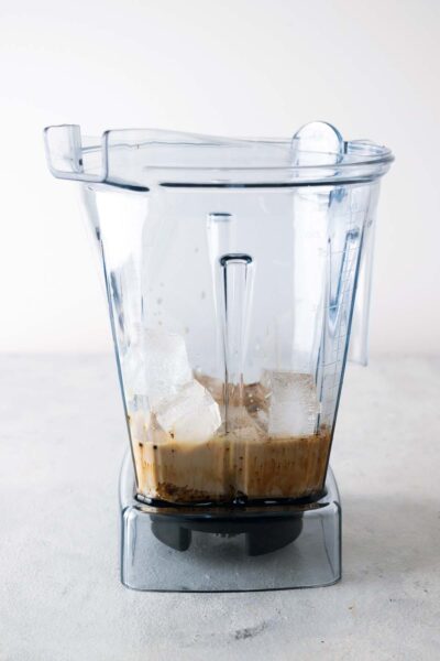 Caramel sauce, instant coffee, milk, ice, and homemade Frappuccino base syrup in a blender. 