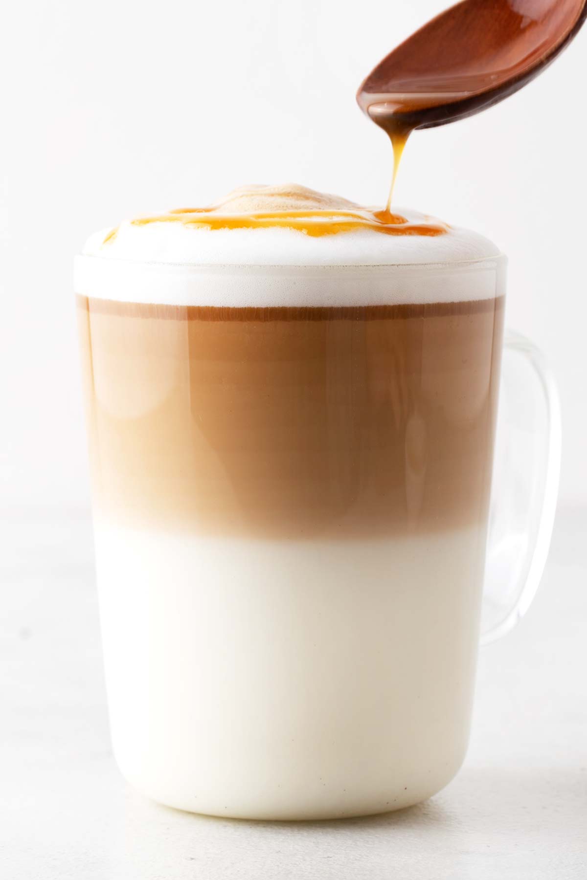 Drizzling caramel sauce on top of a Caramel Macchiato drink.