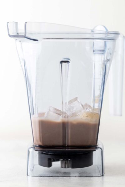 Chocolate sauce, dark chocolate bar, milk, ice, and homemade Frappuccino base syrup in a blender. 