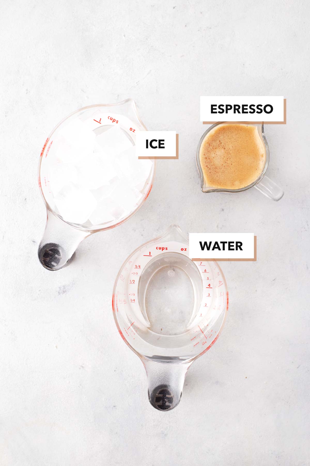 Starbucks Iced Americano Copycat ingredients in clear measuring cups and a small glass.