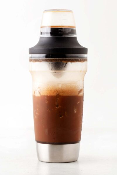 Espresso, chocolate malt powder, and ice in a cocktail shaker. 