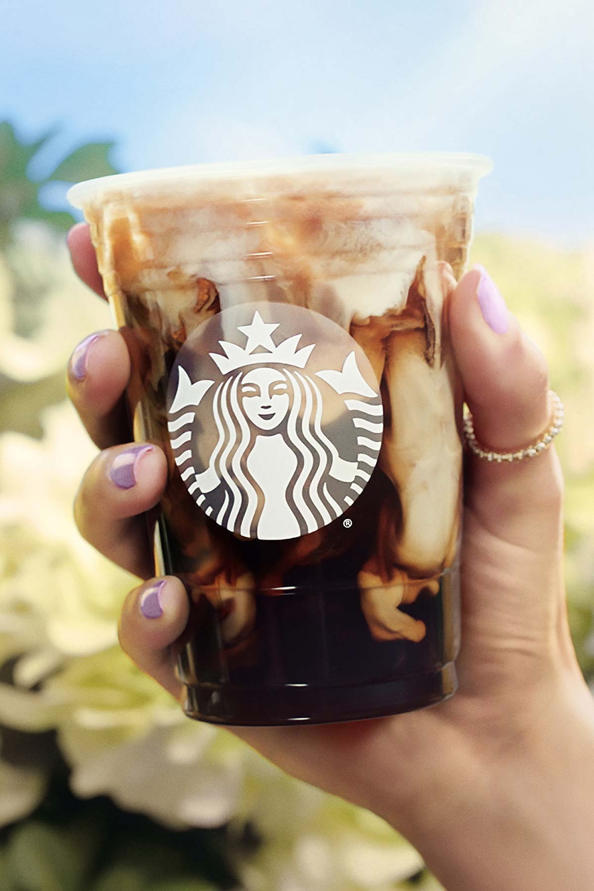 Hand holding an Iced Toasted Vanilla Oatmilk Shaken Espresso in a Starbucks cup.