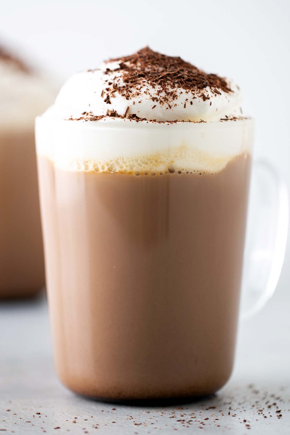 Starbucks Peppermint Mocha Copycat dalam mug bening dengan whipped cream dan cokelat ikal di atasnya.