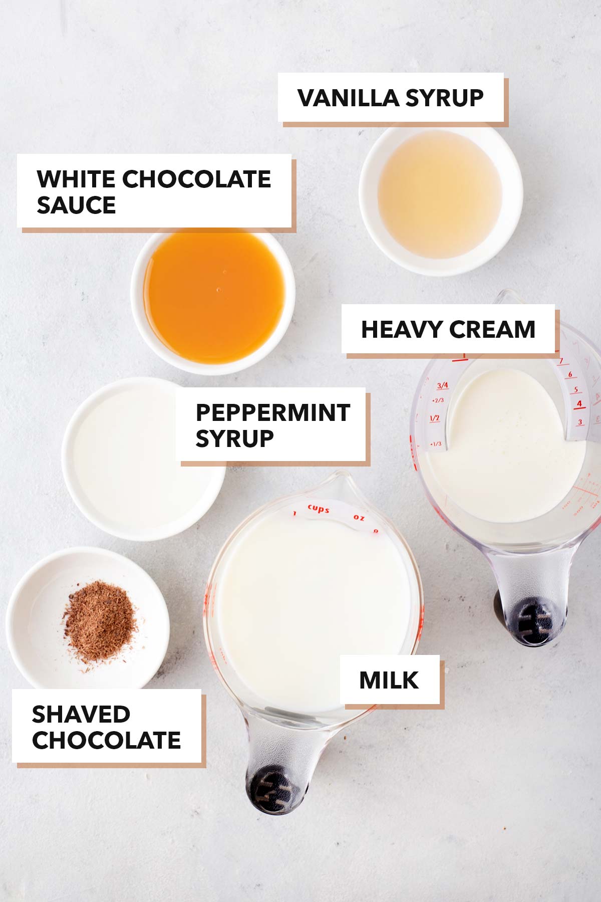 Starbucks Peppermint White Hot Chocolate Copycat ingredients in bowls and cups.
