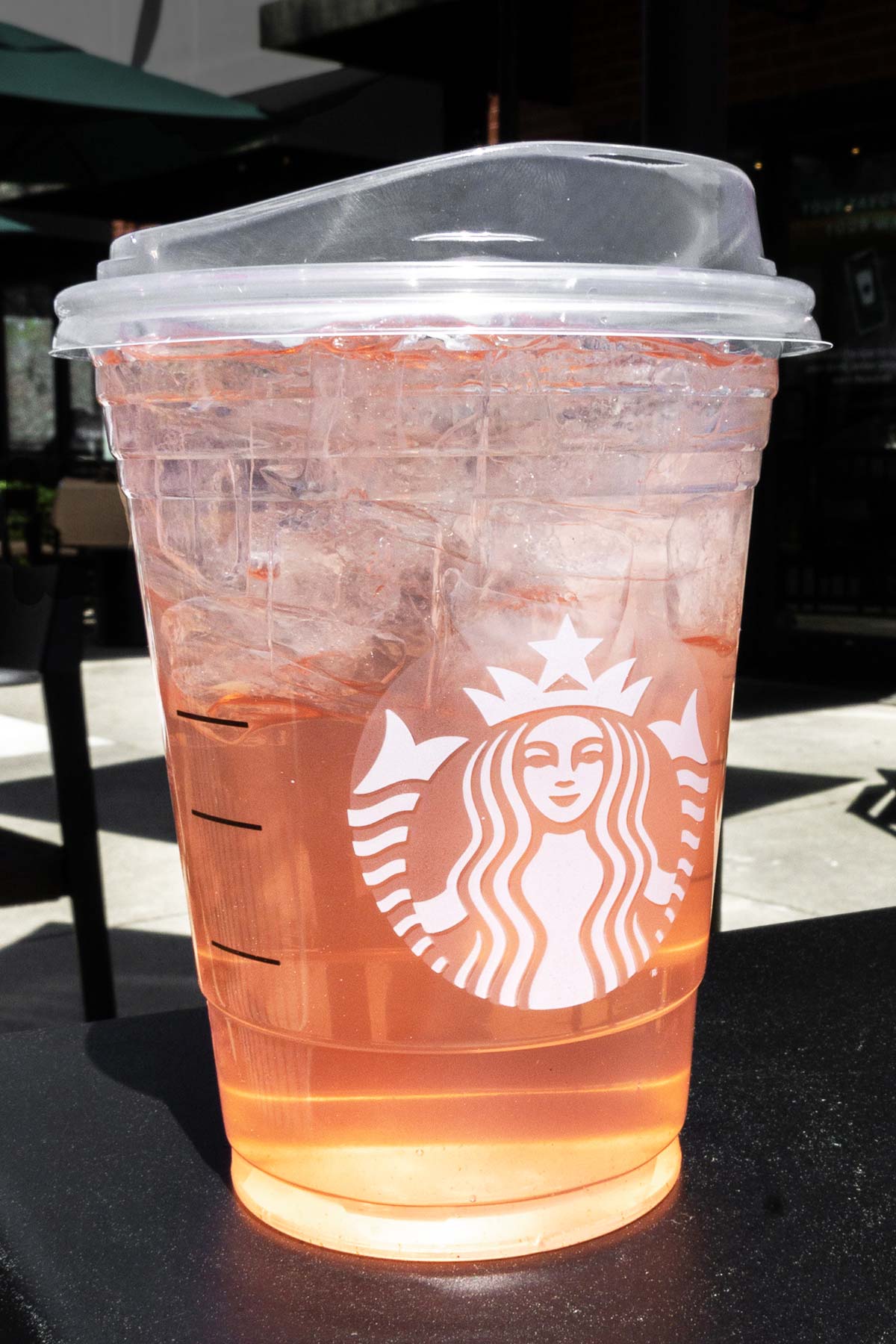 Starbucks secret menu TikTok Rose Gold Refresher drink from the side view of the cup with Starbucks logo and lid on.
