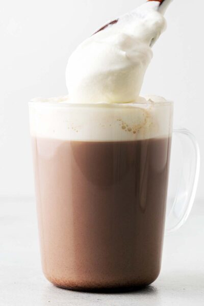 Whipped cream spooned onto a hot chocolate. 