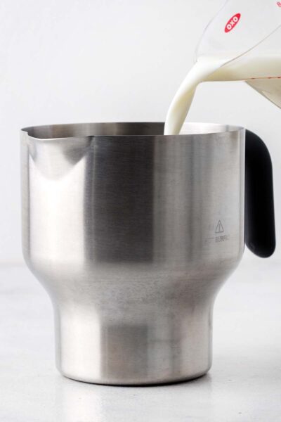 Milk poured into a electric frother. 