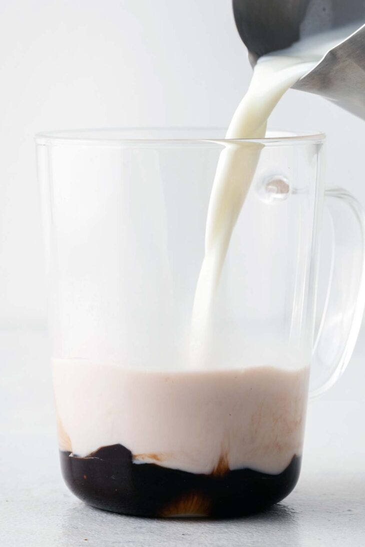 Frothed milk poured into a mug with chocolate syrup. 