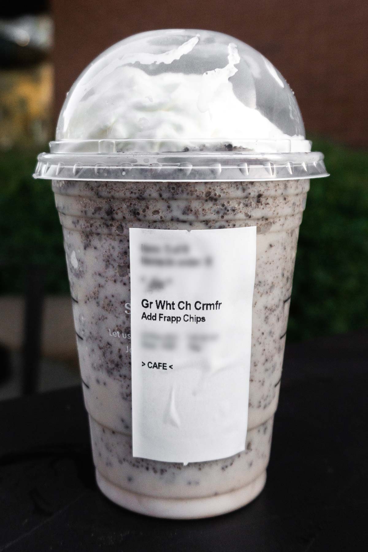 Cookies and Cream Frappuccino in a Starbucks cup, side view with the order label.