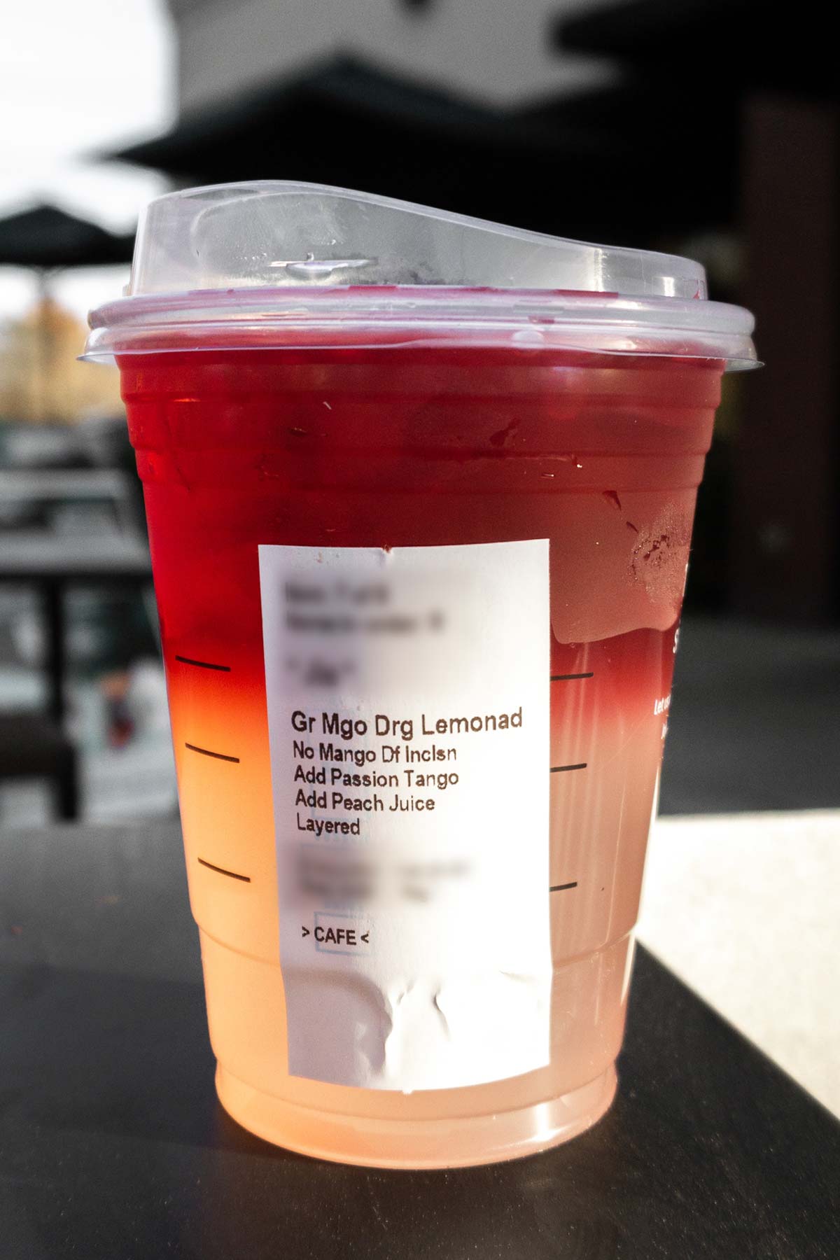 Starbucks Mango Dragonfruit Lemonade in a cup with a lid and ingredients on the label.