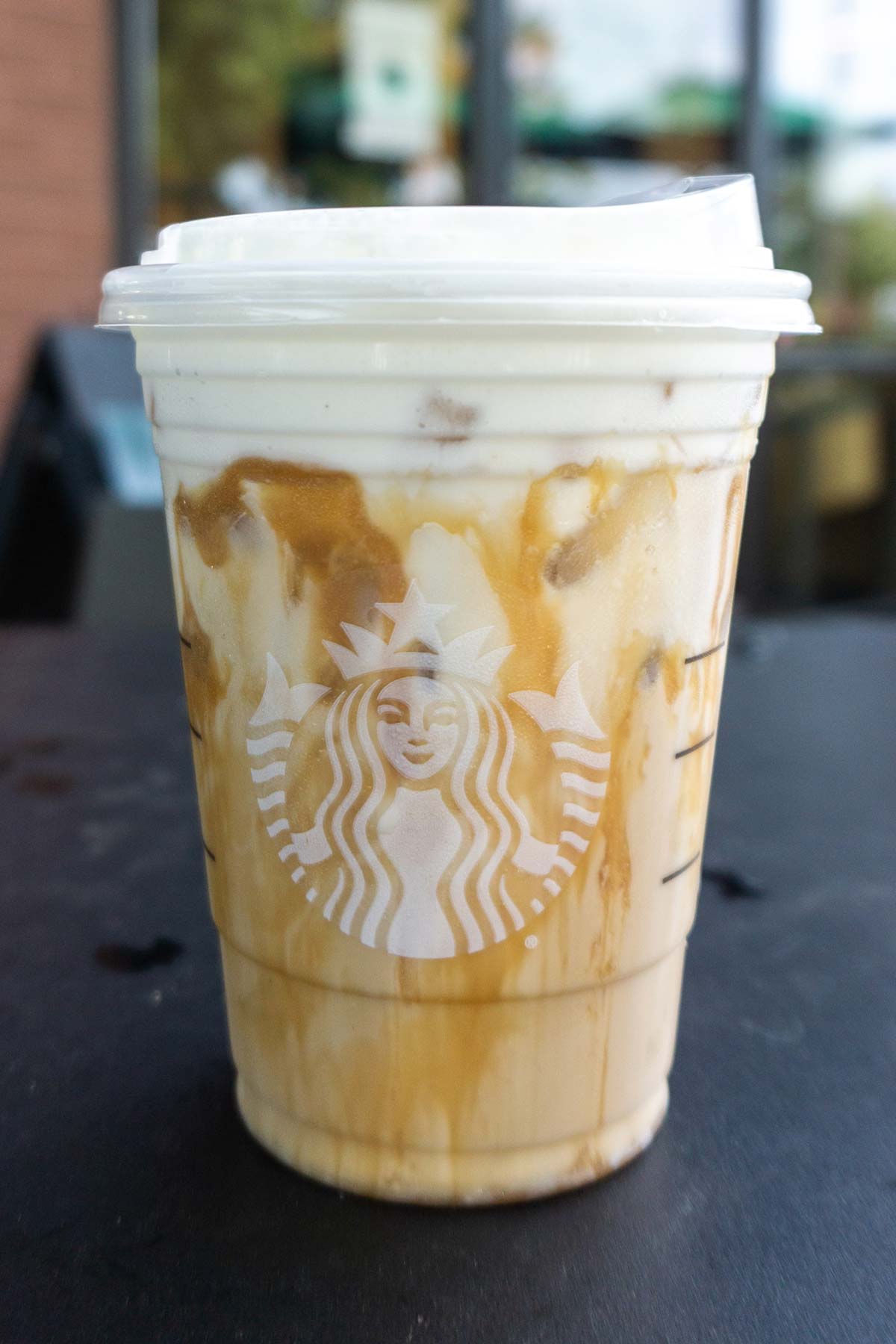 Iced White Mocha with Sweet Cream Foam with extra caramel drizzle Starbucks drink in a cup.