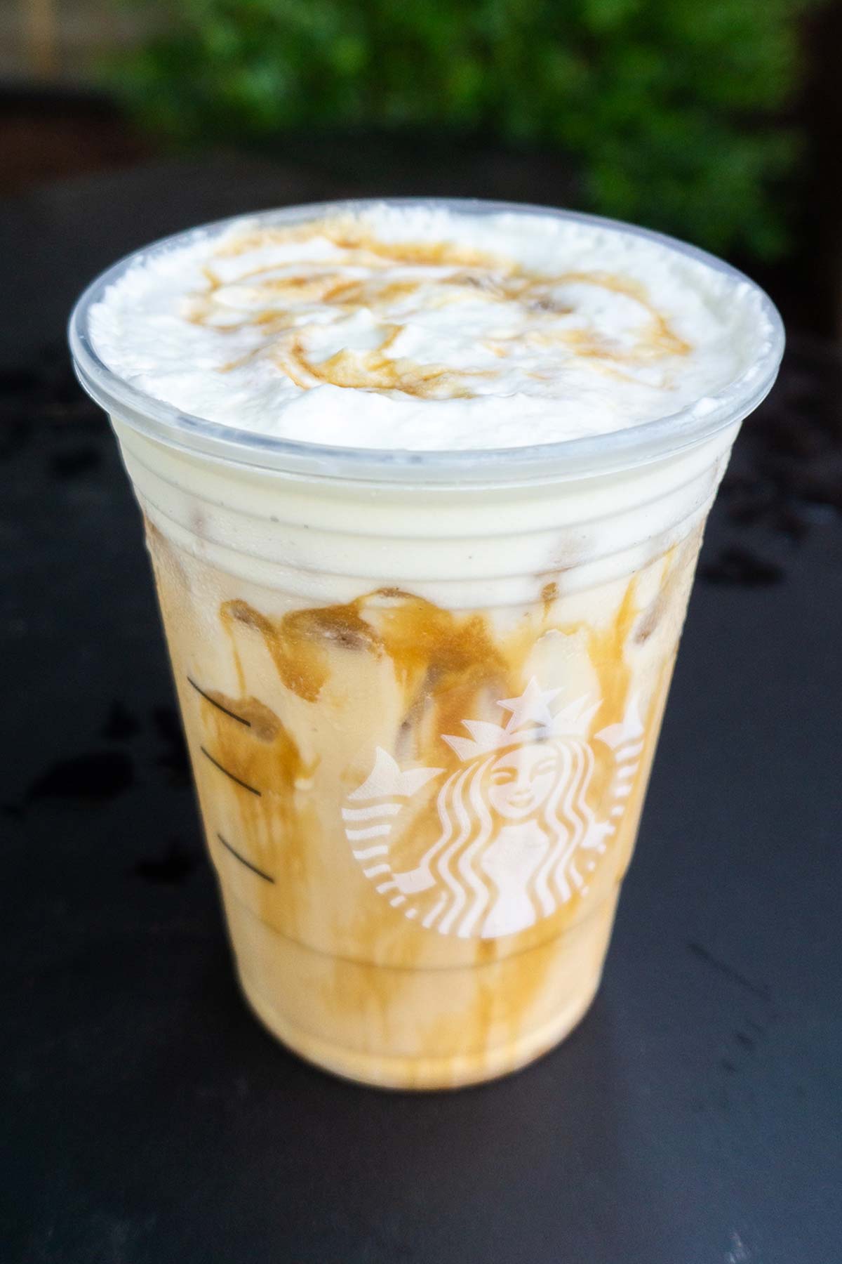 Starbucks Iced White Mocha with Sweet Cream Foam and extra caramel drizzle drink.