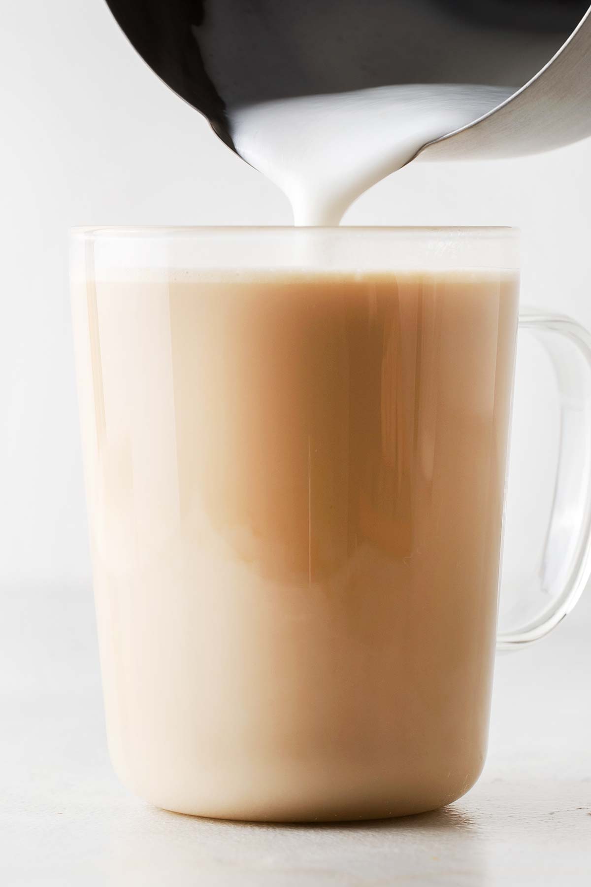 Minuman peniru Starbucks Vanilla Latte dengan susu kukus dituangkan ke dalam cangkir.