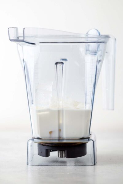 White chocolate sauce, milk, ice, and homemade Frappuccino base syrup  in a blender. 