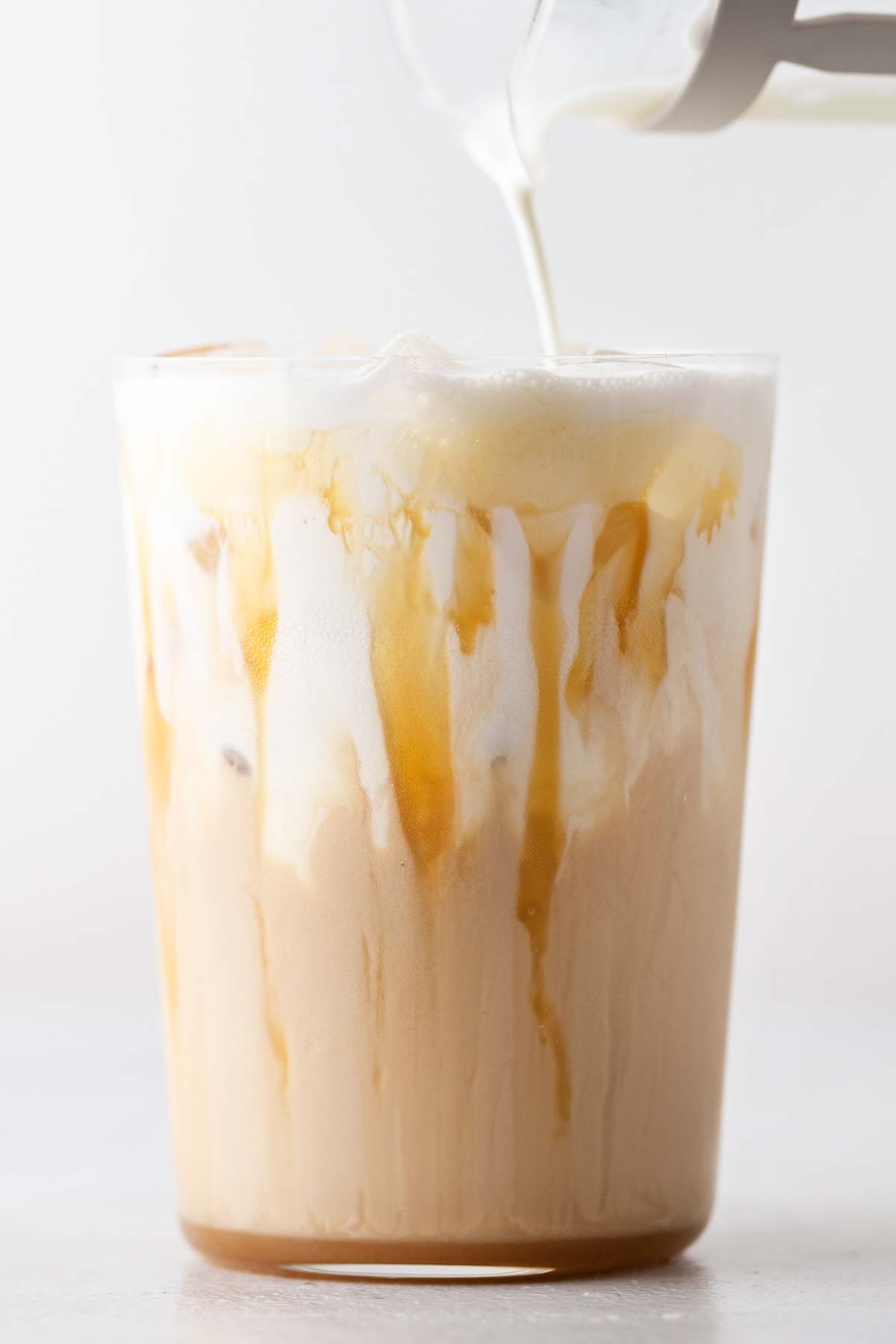 TikTok Starbucks Iced White Mocha copycat drink in a cup with caramel drizzle and cold foam.
