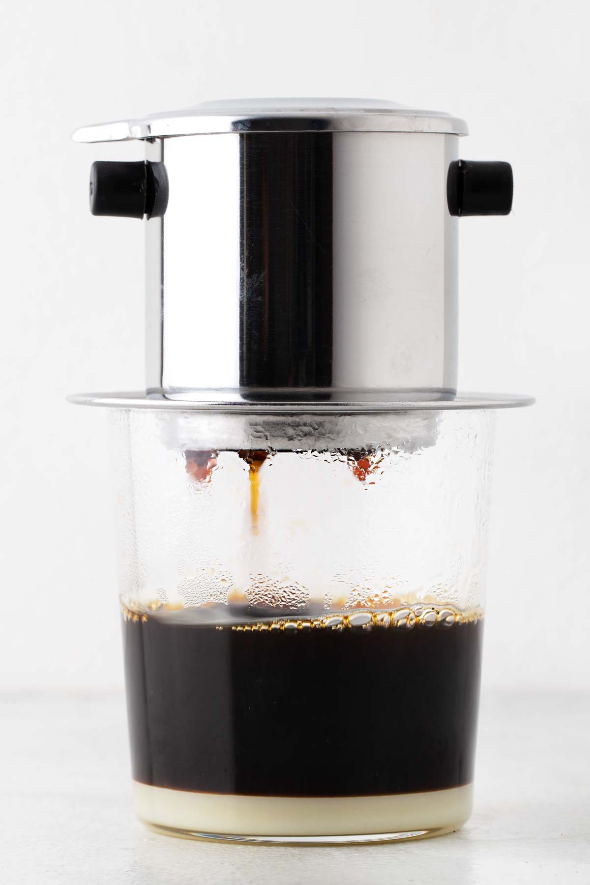 Vietnamese coffee dripping down from a phin filter.