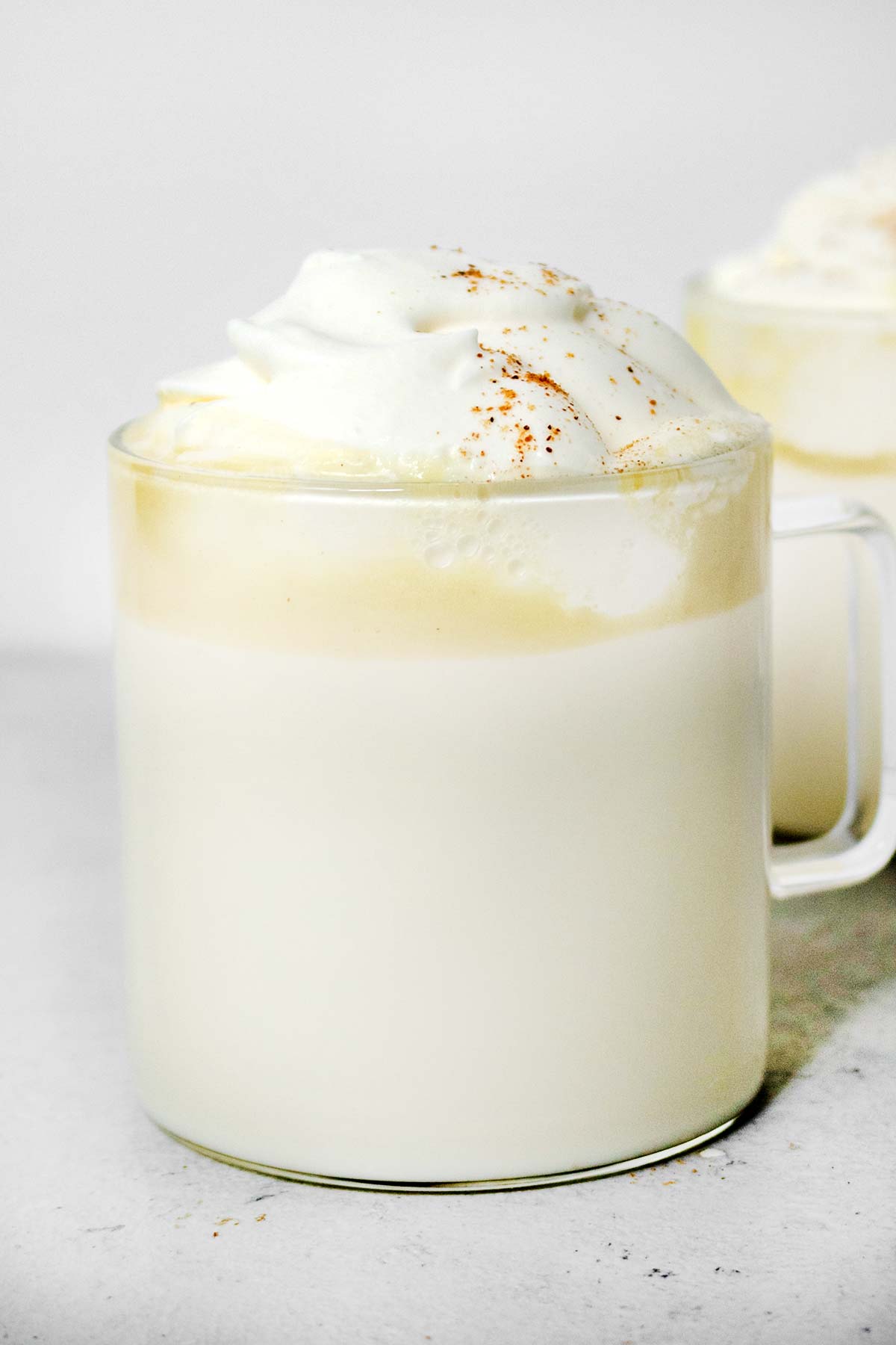 White hot chocolates with whipped cream in mugs.